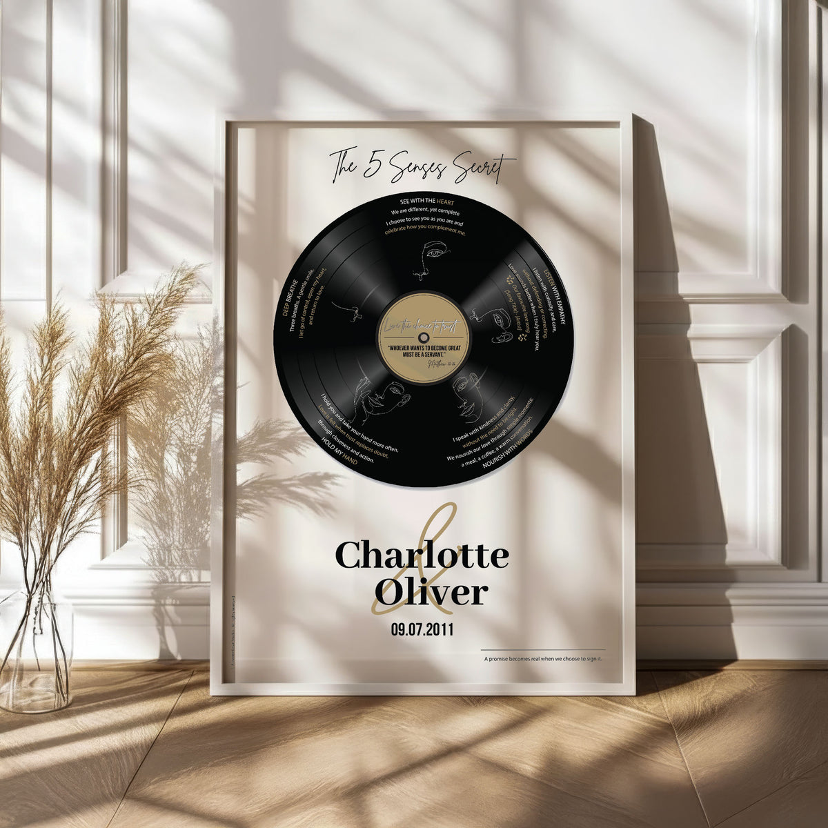 Personalised vinyl record couples poster in white frame beside pampas grass in sunlit room